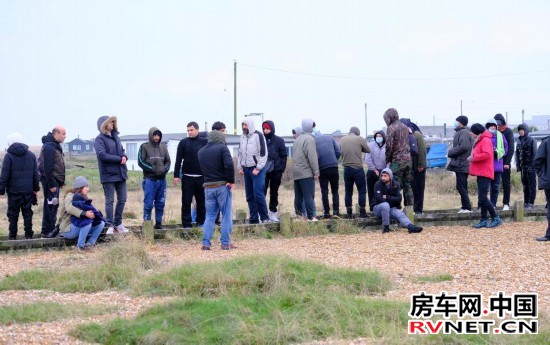 2021年11月24日，移民在抵达英国邓杰内斯角海岸后等待。新华社发（史蒂夫·芬恩摄）